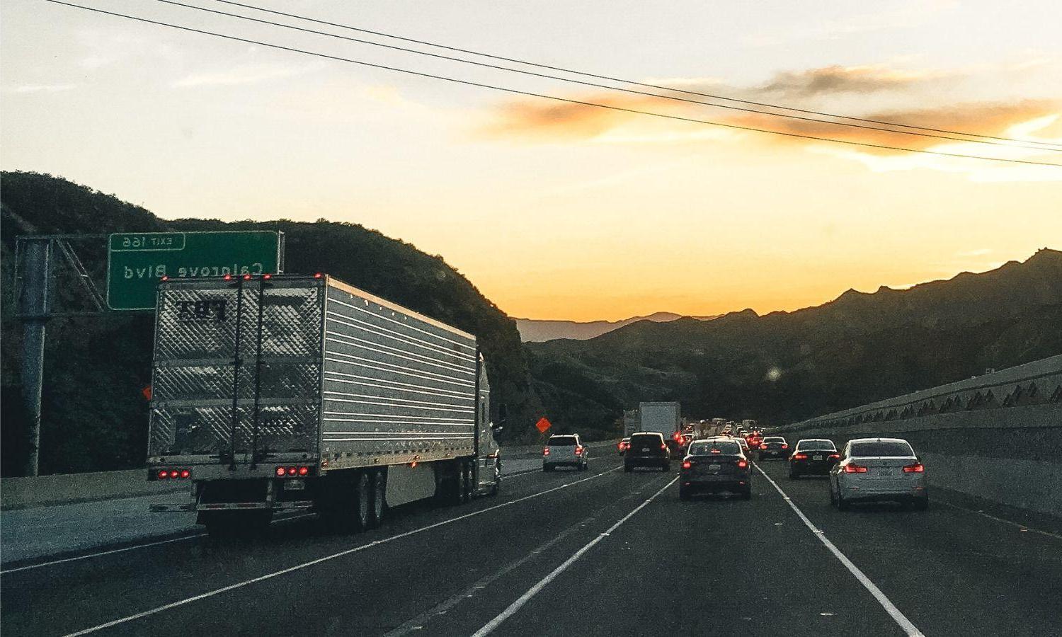 Heavy duty trucks 和 smaller cars stuck in traffic.